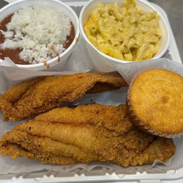 Marie's Soul Food fried fish, rice and beans, macaroni and cheese, and cornbread in a takeout container.