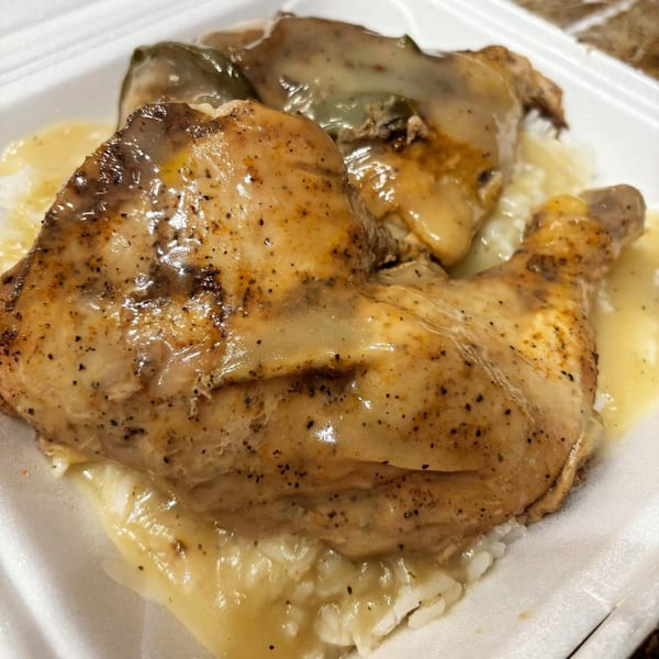 Marie's Soul Food chicken and gravy over rice, served in a white takeout container.