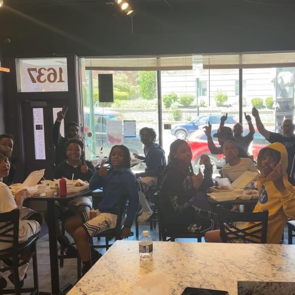 A group of young people enjoying a meal together at Marie's Soul Food restaurant.